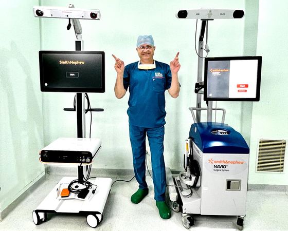 Surgeon standing with the NAVIO robotics platform in theatre