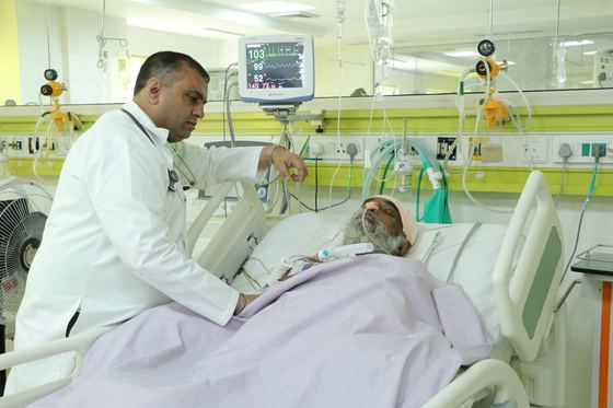 A consultant reviewing a patient in critical care